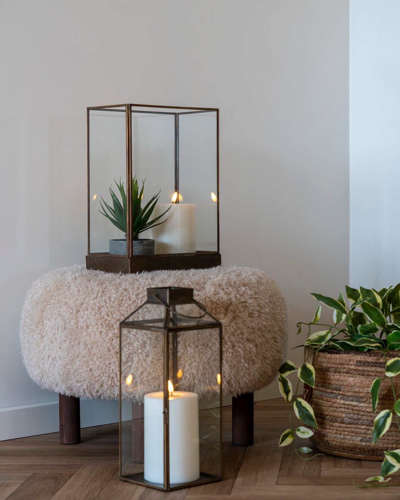Cremefarvet teddy puf stylet med lanterner og grønne planter
