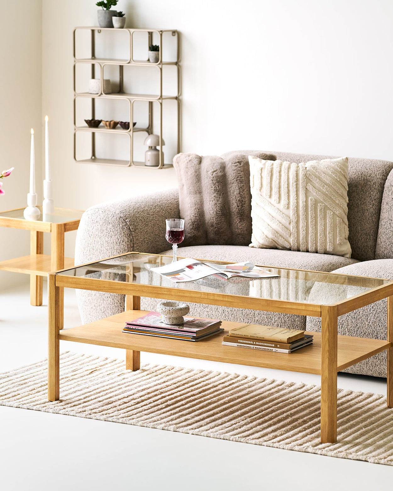 Beige vægreol over sofa i lys nordisk indretning

