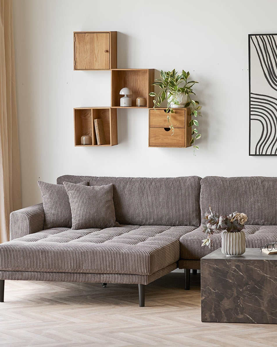 Væghængt opbevaring i egetræ over sofa – dekorativ løsning med hylder og skuffemodul