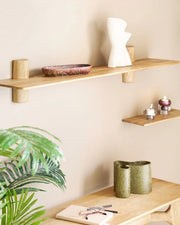 Lang væghylde i natur eg med keramikvase og dekorativ skål, stylet over skrivebord i skandinavisk indretning.