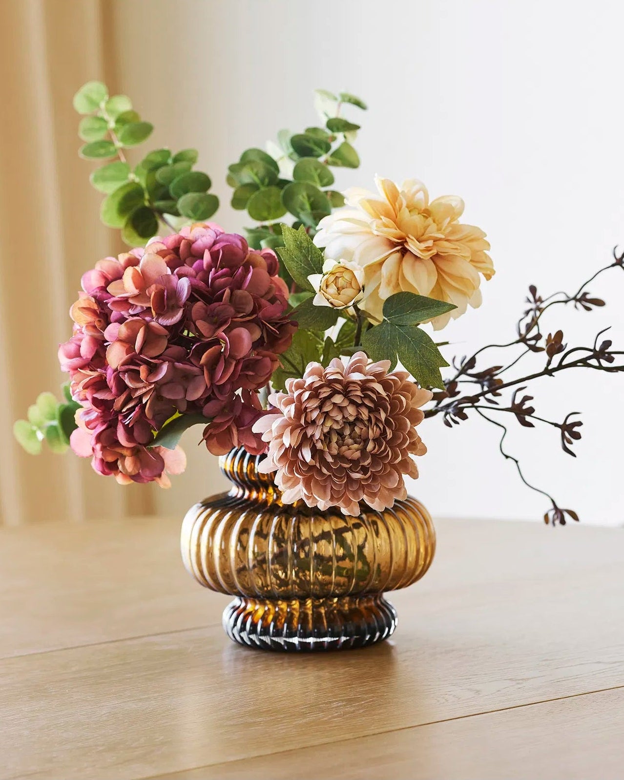 Glasvase i røget brun med falske blomster i