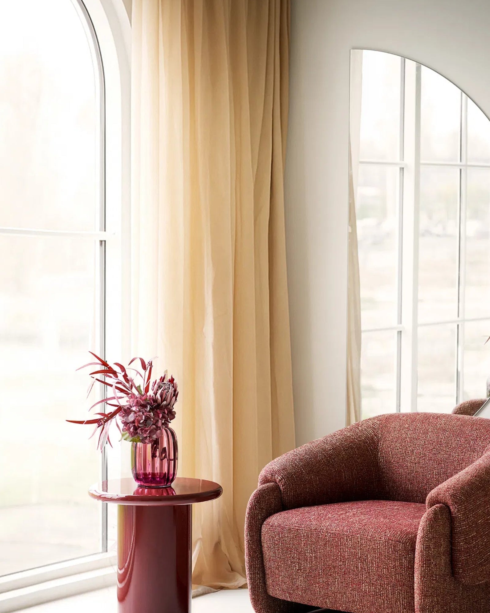 Rose vasen sammen med smuk stol i Burgundy farver, afbilledet med dekorative elementer