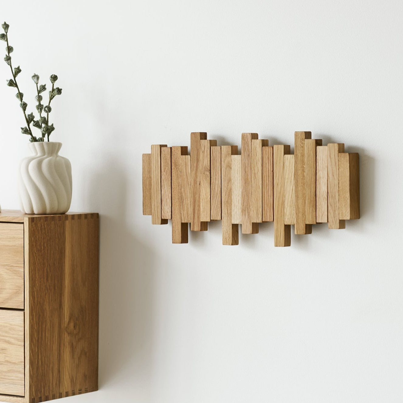 Ege knagerække i massivt egetræ med fire kroge monteret på hvid væg - design knagerække