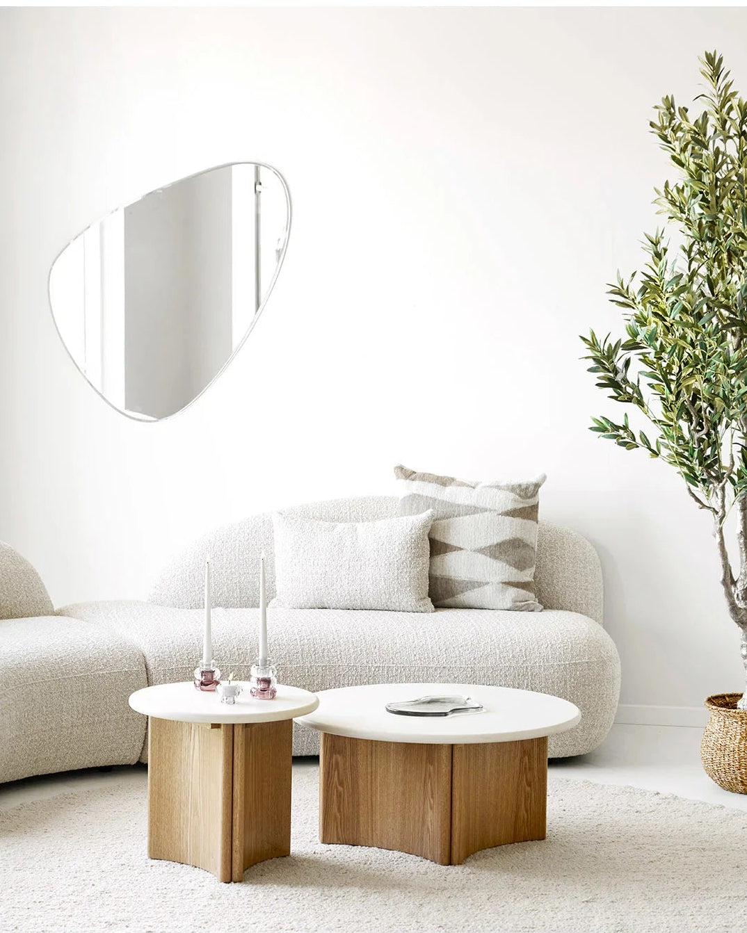 Klar glasbakke på sofabord i lys minimalistisk stue med egetræ og bouclésofa
