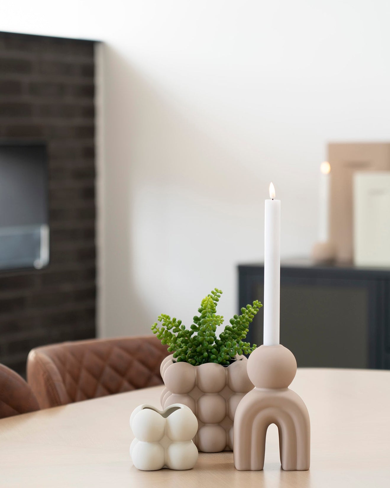 Beige lysestage og dekorative vaser på lyst spisebord