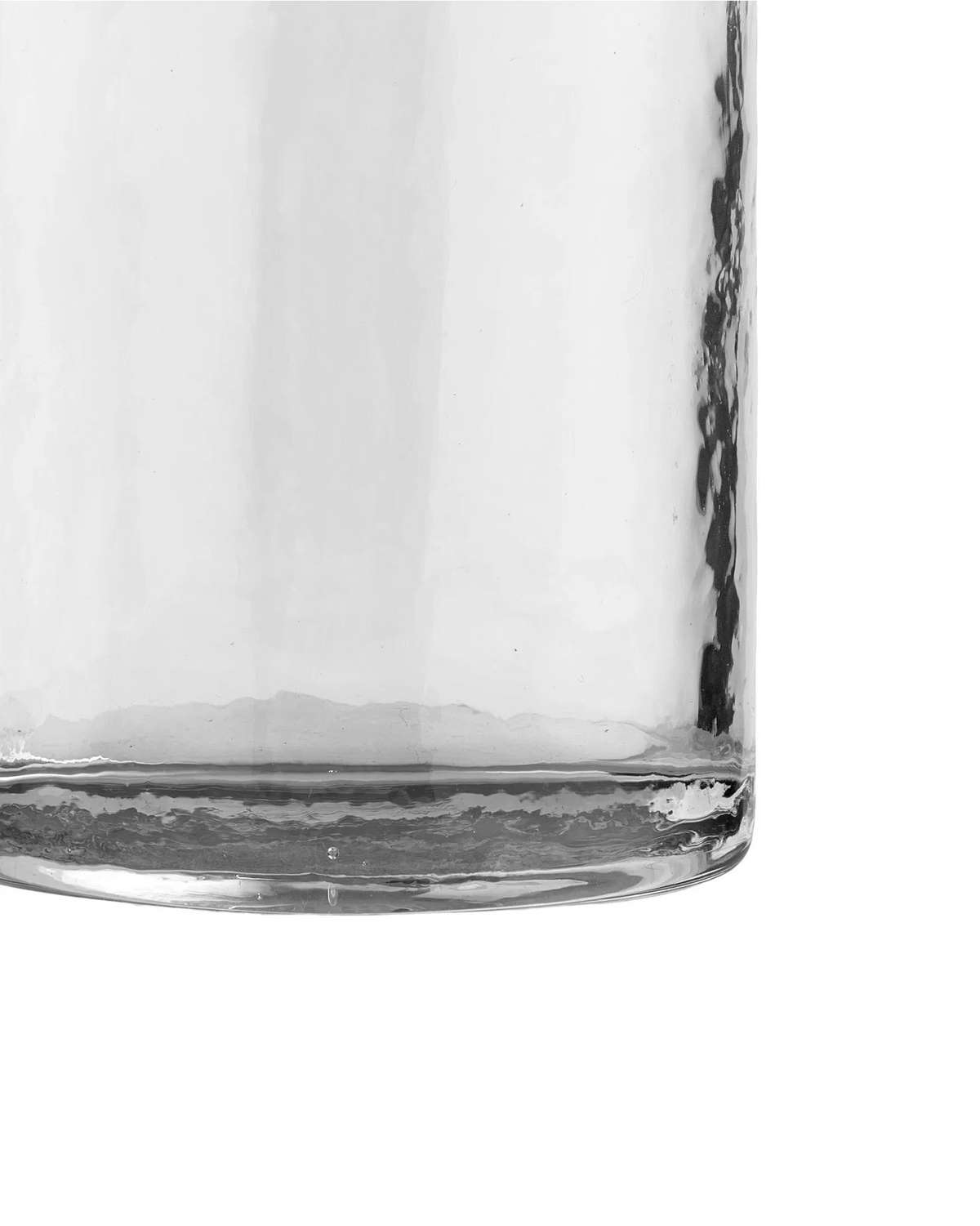 Detaljebillede af klart drikkeglas med let ujævn struktur og kraftig glasbund.