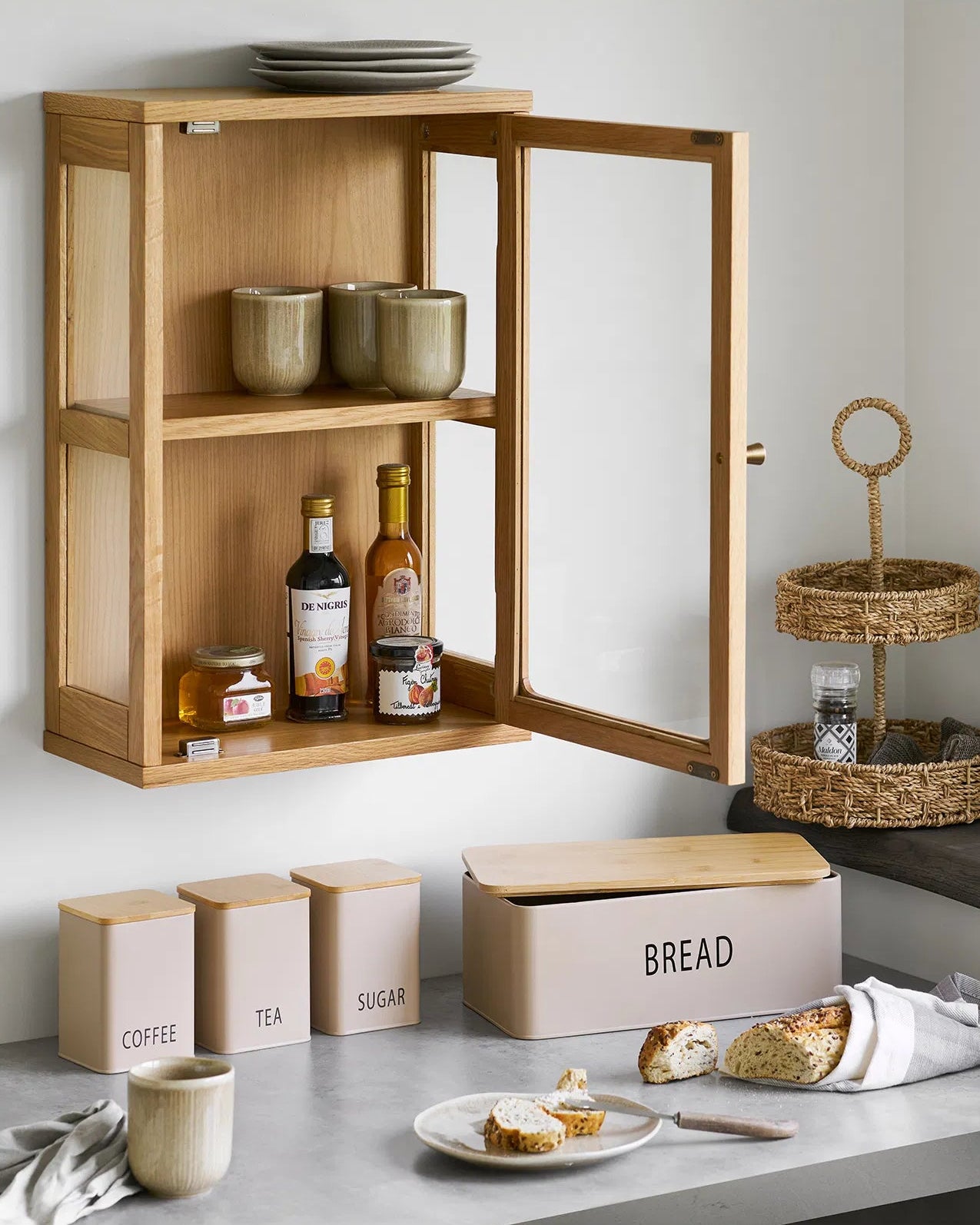 Køkkensæt i bambus og metal placeret i køkkenet sammen med andre dekorative elementer for at skabe hygge