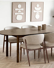 To abstrakte vægdekorationer i beige og creme over spisebord i nordisk indretning