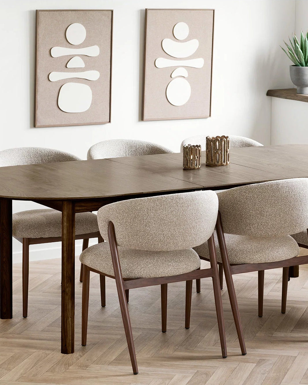 To abstrakte vægdekorationer i beige og creme over spisebord i nordisk indretning