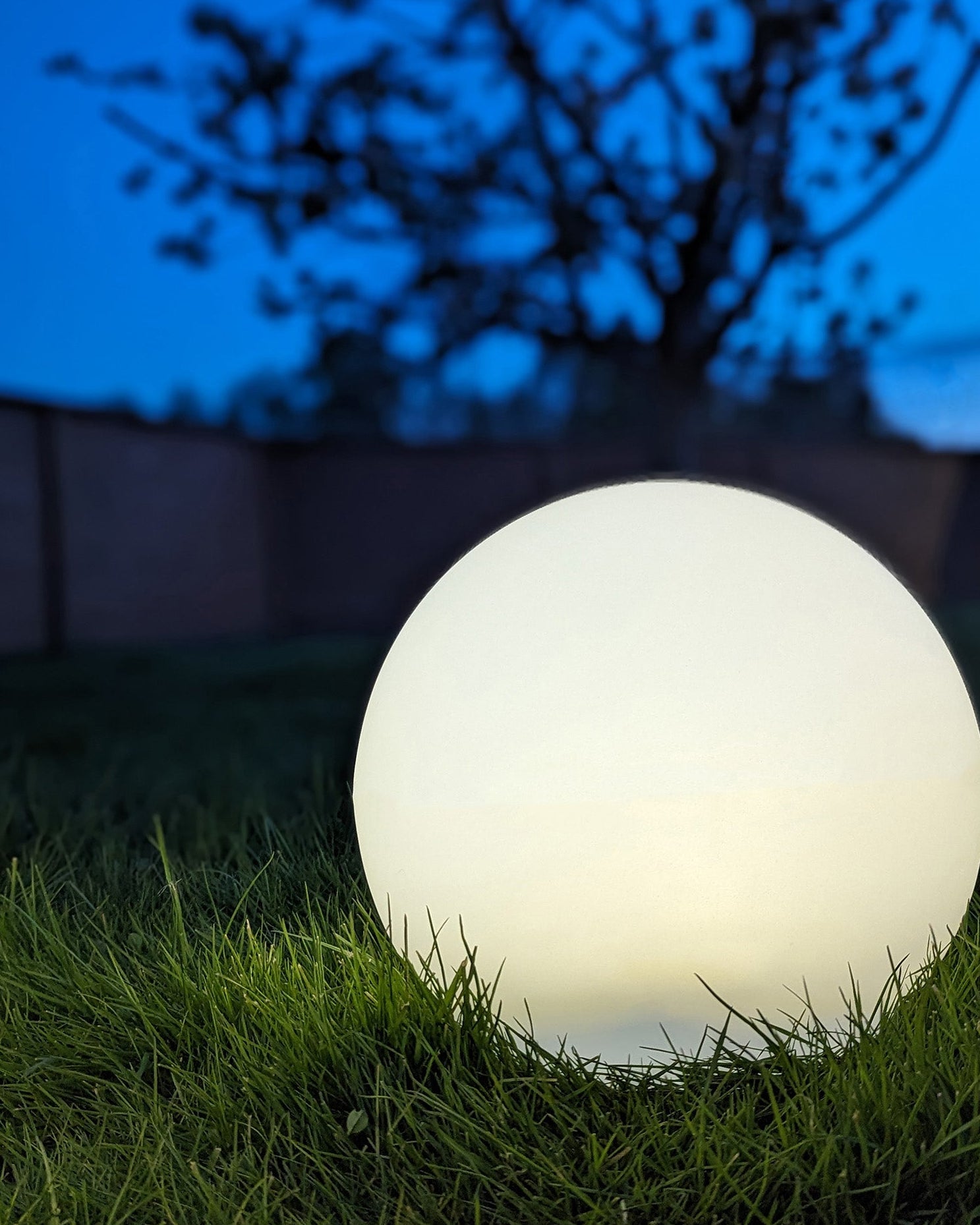 LED kuglelampe til haven med varmt hvidt lys i græsplæne

