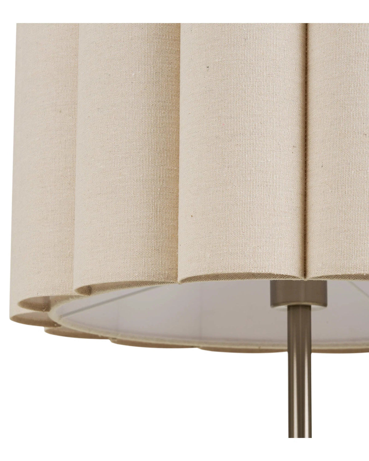 Detalje af beige lampeskærm i tekstil med plisseret design og synlig stofstruktur.