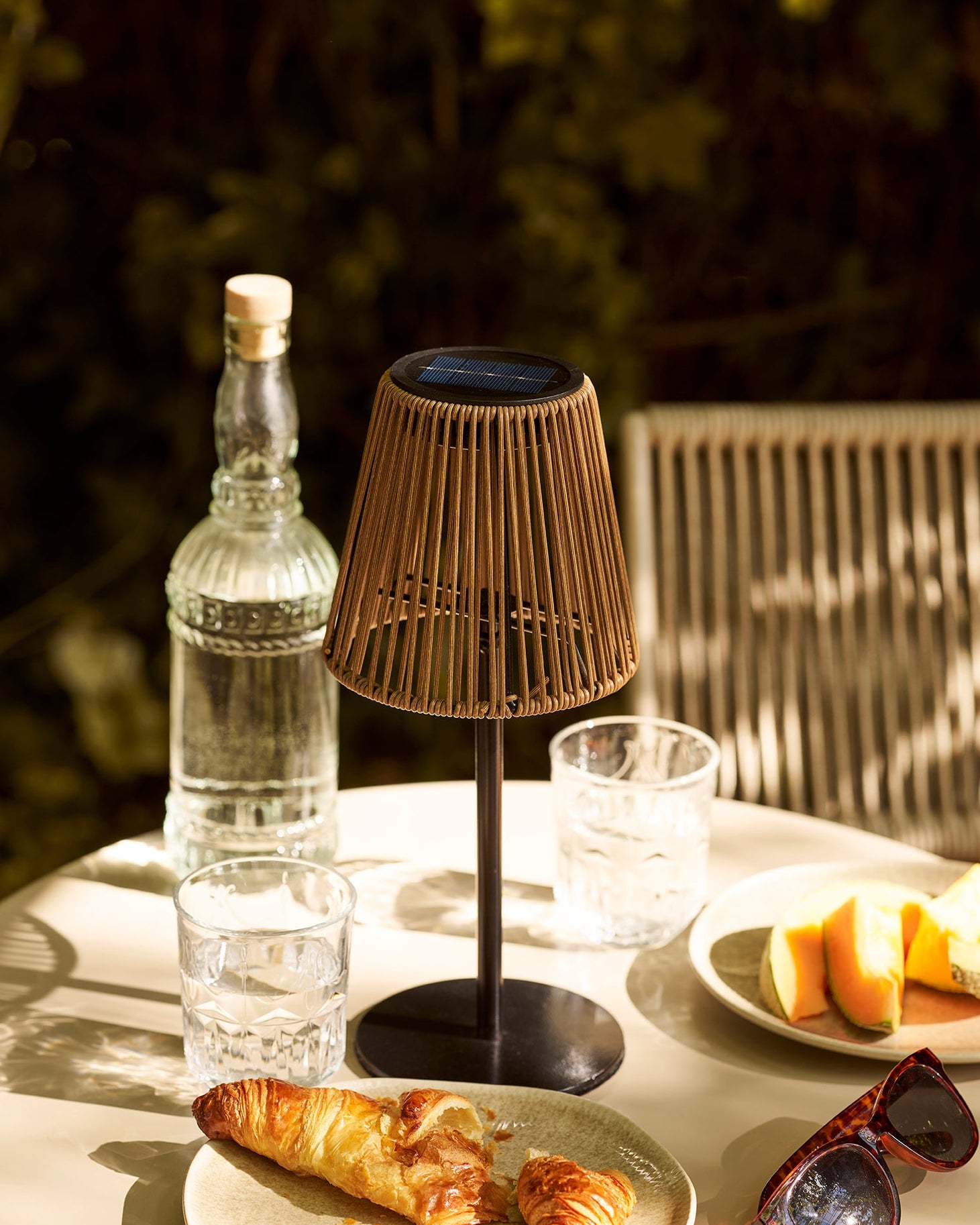 Elora solcelle lampe i polyrattan på bord med morgenstemning og naturligt lys