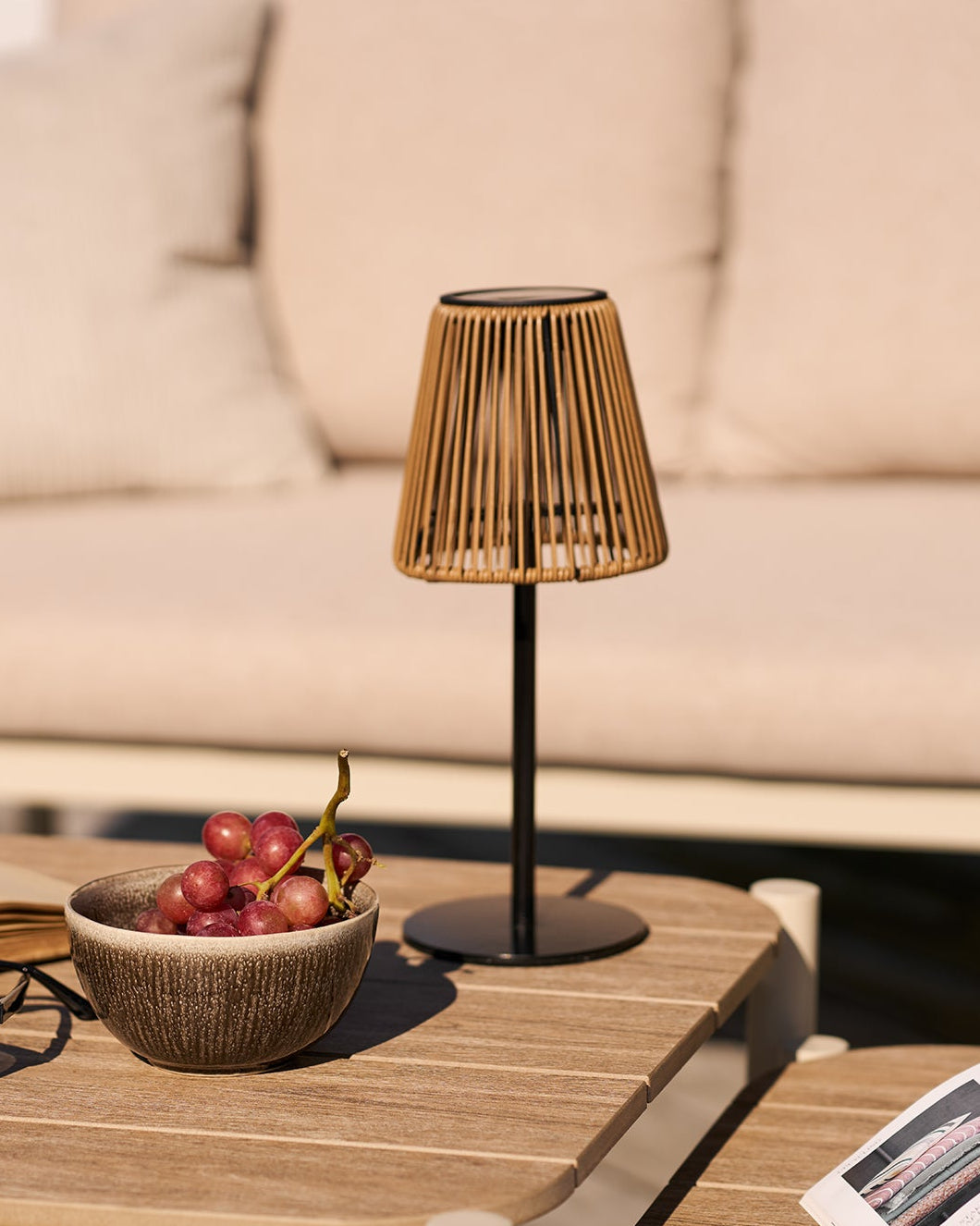 Elora lampe i polyrattan på bord med afslappet udendørs stemning