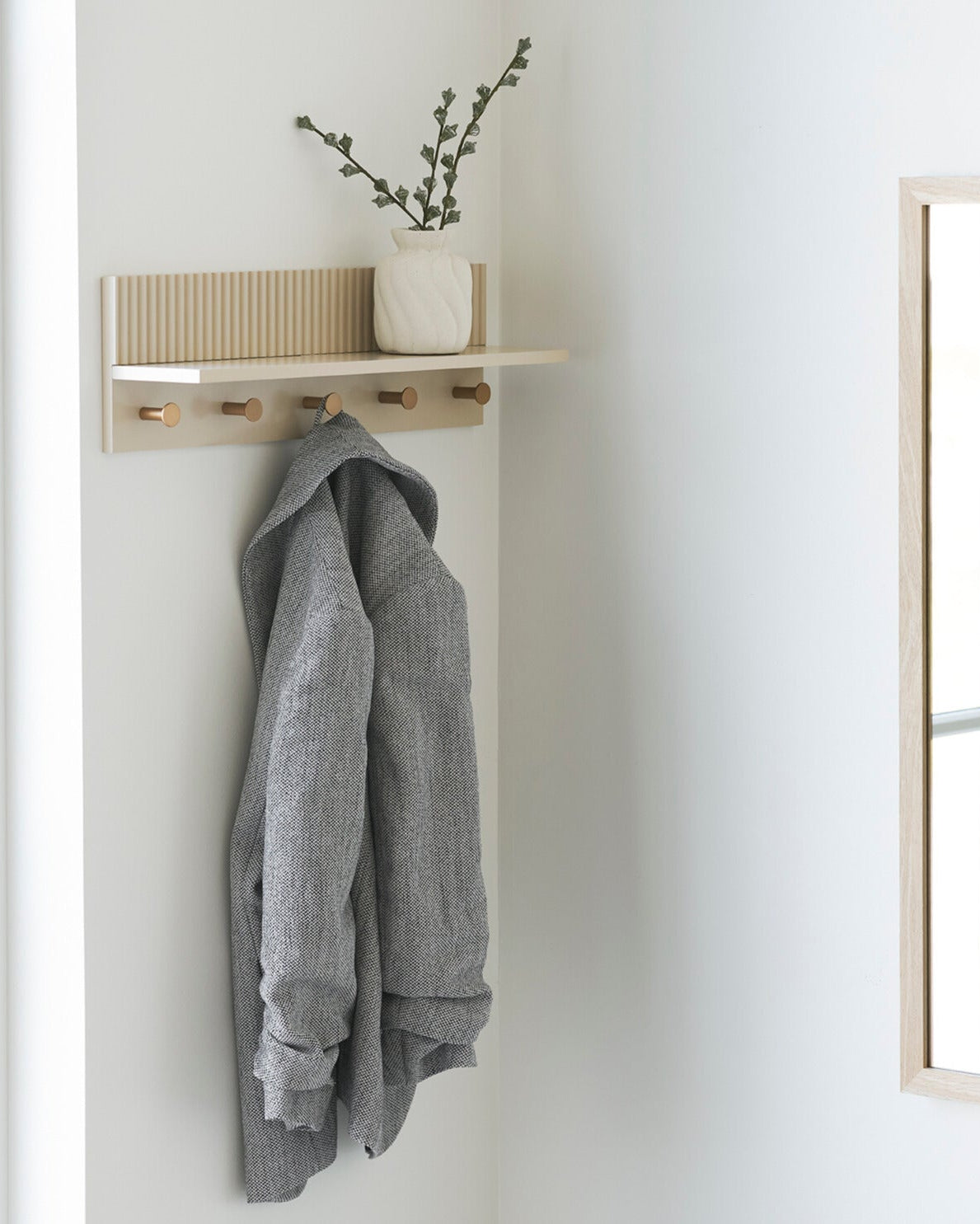 Knagerække med hylde i beige og messing i nordisk entré