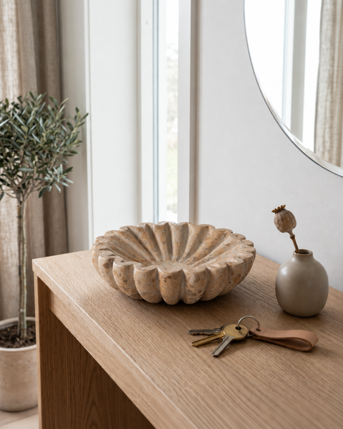 Beige Marmorskål med naturlige åretegninger i entre med spejl, nøgler og plante