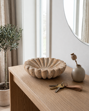 Beige Marmorskål med naturlige åretegninger i entre med spejl, nøgler og plante