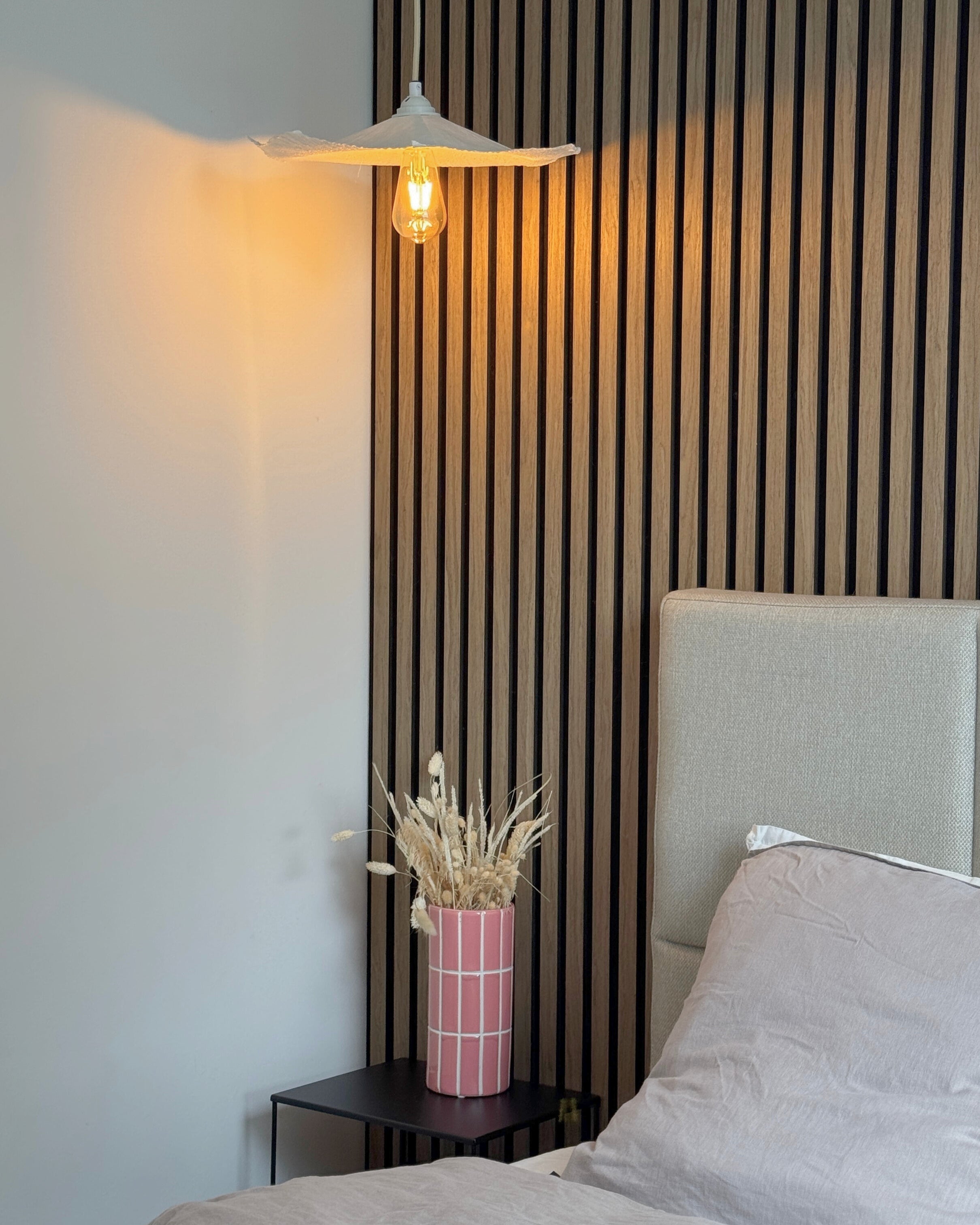 Liv flisevase på sengebord i soveværelse med lampe
