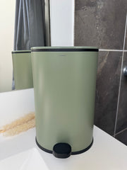 Cosmic toiletspand i oliven med sort pedal og låg, stående på badeværelse