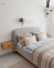 Væghængt skuffe i lyst egetræ med minimalistisk design, synlig træstruktur og rundt greb i nordisk soveværelse som sengeborde
