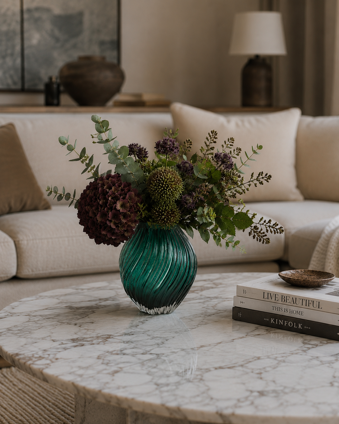 Mørkegrøn vase i stue med friske blomster i på sofabord