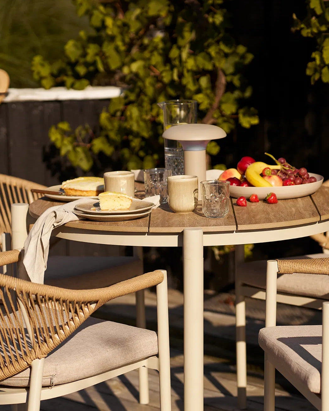 Sommerligt dækket bord på terrassen med Kyst keramikkrus brugt til servering af kaffe i solen.
