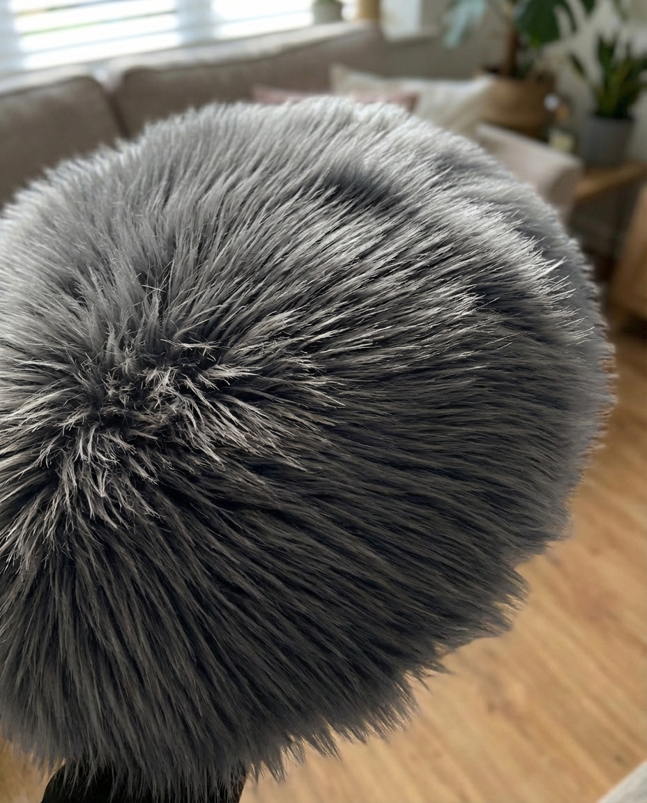 Luna faux fur hynde i sort placeret på en rustik træbænk i en moderne entré