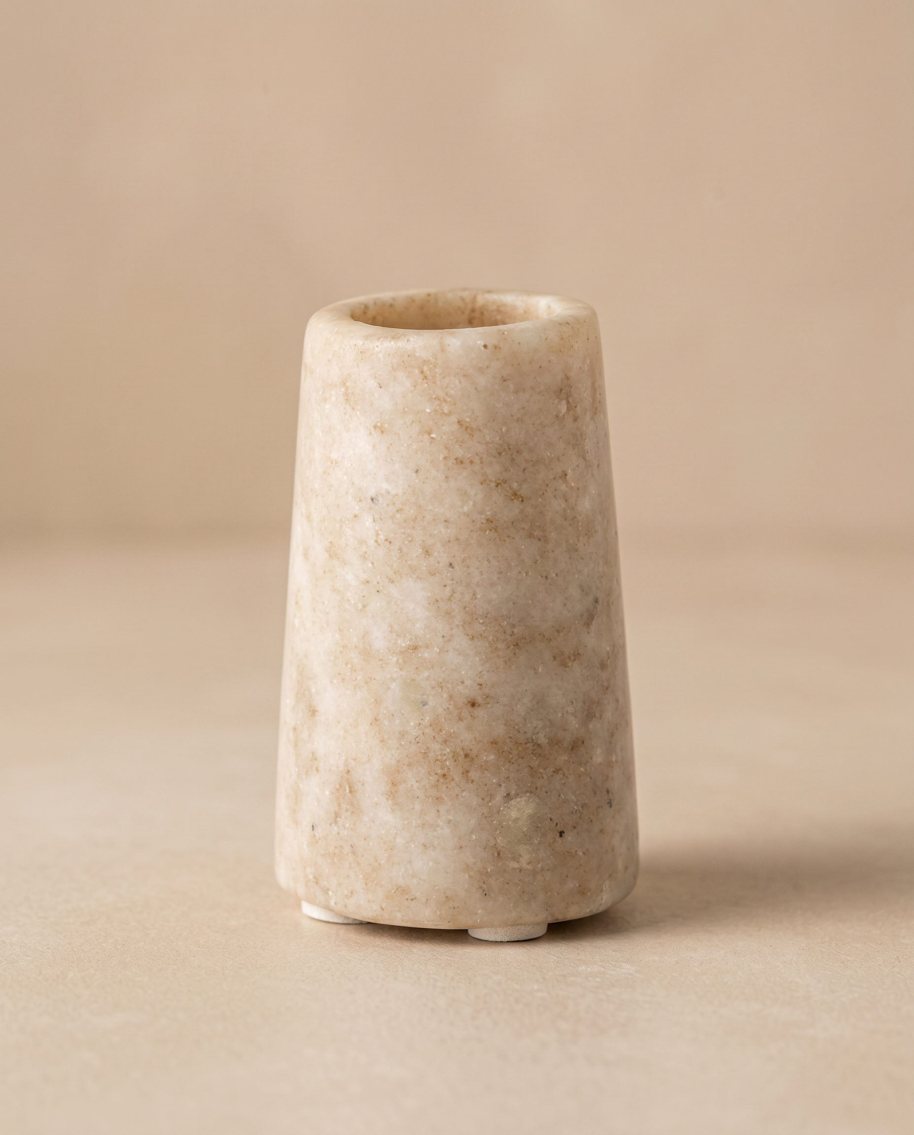 Konisk marmor lysestage på beige baggrund