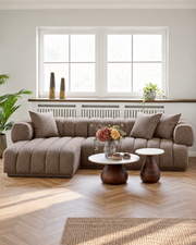 Aurora sofa i brun med venstrevendt chaiselong og tre puder i en lys stue med runde sofaborde.