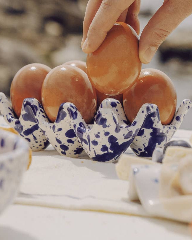 Keramisk æggebakke med seks friske æg på morgenbord
