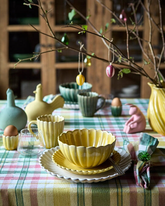 Flor kop i gul sammen med hele Flor serien på påskedækket bord