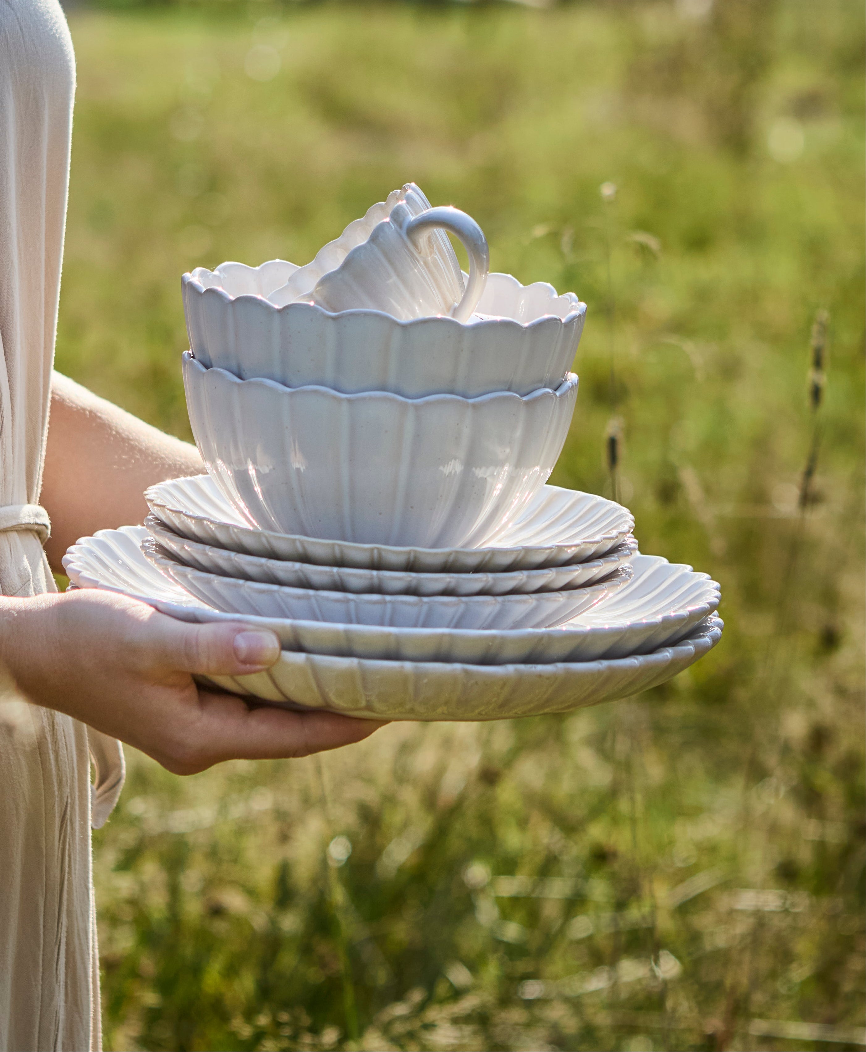 Hele Flor serien i off white holdes i hænderne på en mark
