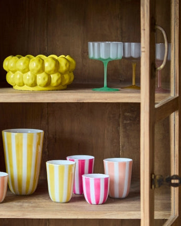 Lily Glas i gul og grøn i vitrineskab med andet boliginteriør bla citronskål