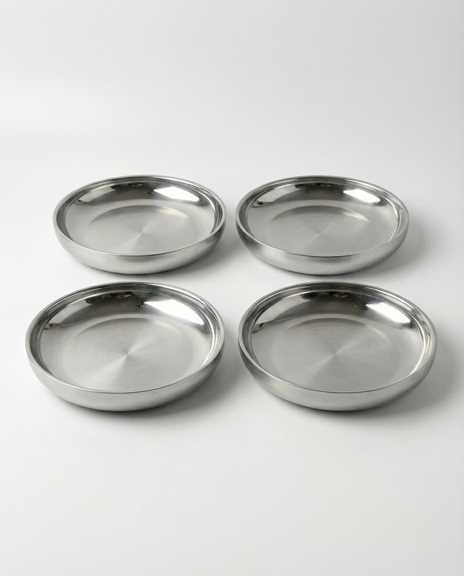 Tæt på-billede af 4 stk store ståltallerken (24 cm) på en hvid baggrund, der viser den børstede finish og den dybe kant.